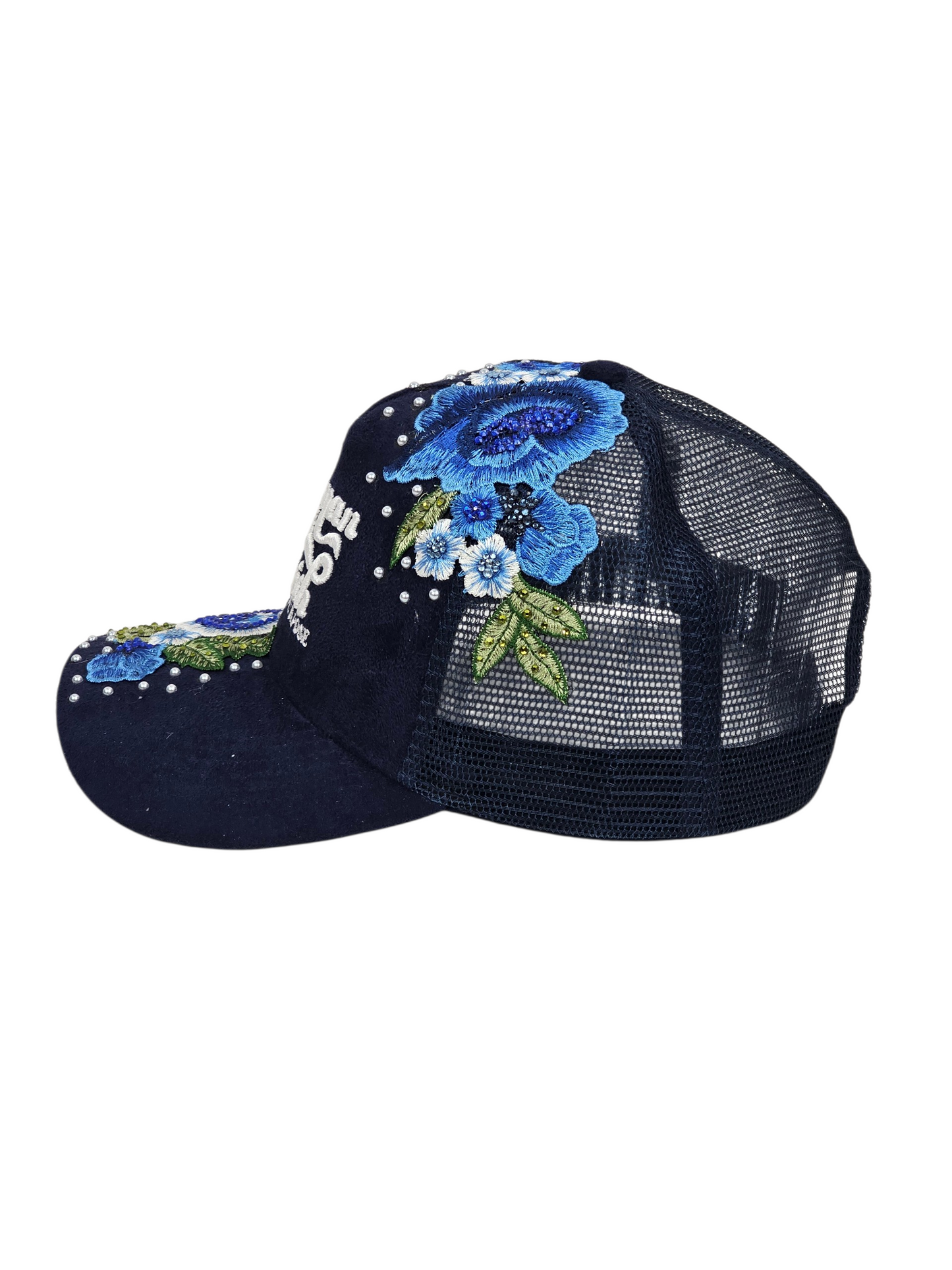 A navy blue trucker-style baseball cap with a mesh back, decorated with blue and white floral embroidery, green leaves, and white rhinestones on the brim and crown.