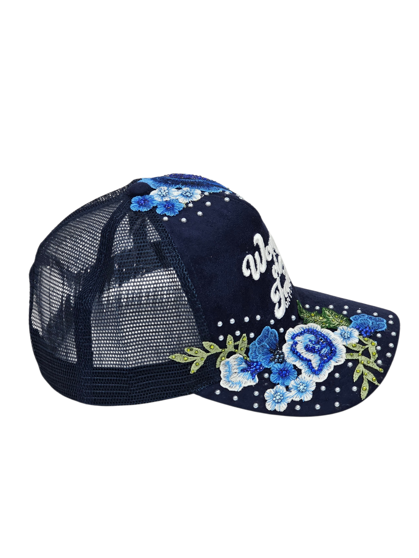 A navy blue trucker-style cap with a mesh back, decorated with blue and white floral sequins, green leaves, and white rhinestone script on the brim.