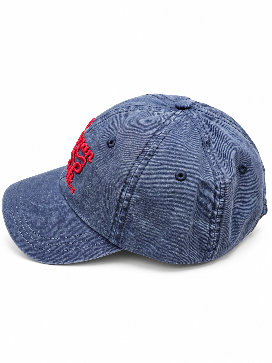 A washed blue denim baseball cap featuring red embroidered text on the side, photographed on a clean white background.